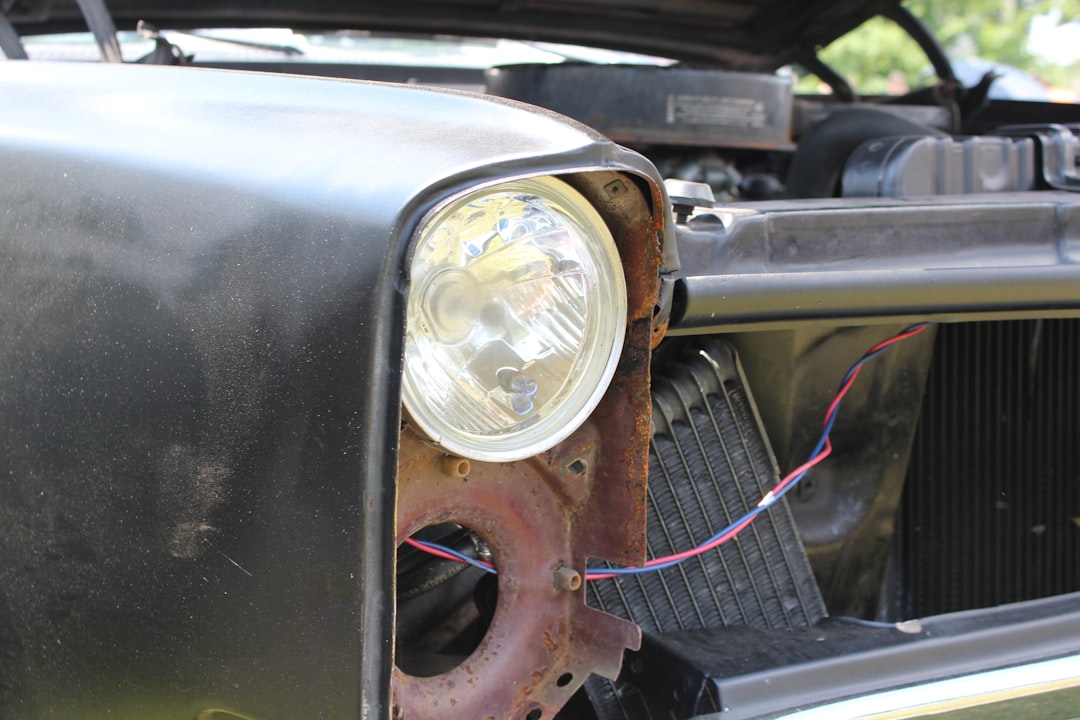 A car's headlight and engine bay are visible.