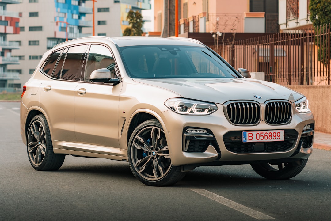 a white bmw suv driving down a city street