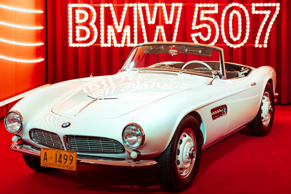 Vintage BMW 507 Cabriolet showcased against a vibrant red background, exuding luxury and nostalgia.