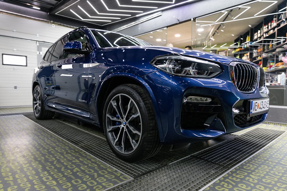 A sleek blue BMW X3 SUV showcased inside a contemporary garage setting.