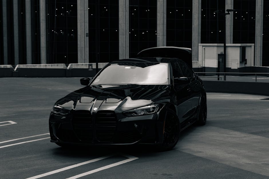 A stylish black BMW M3 on a rooftop in Chicago with skyscrapers in the background.