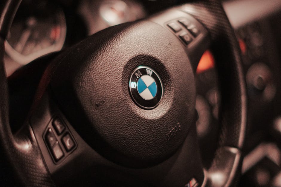 Detailed view of a BMW car steering wheel, highlighting luxury automotive design.