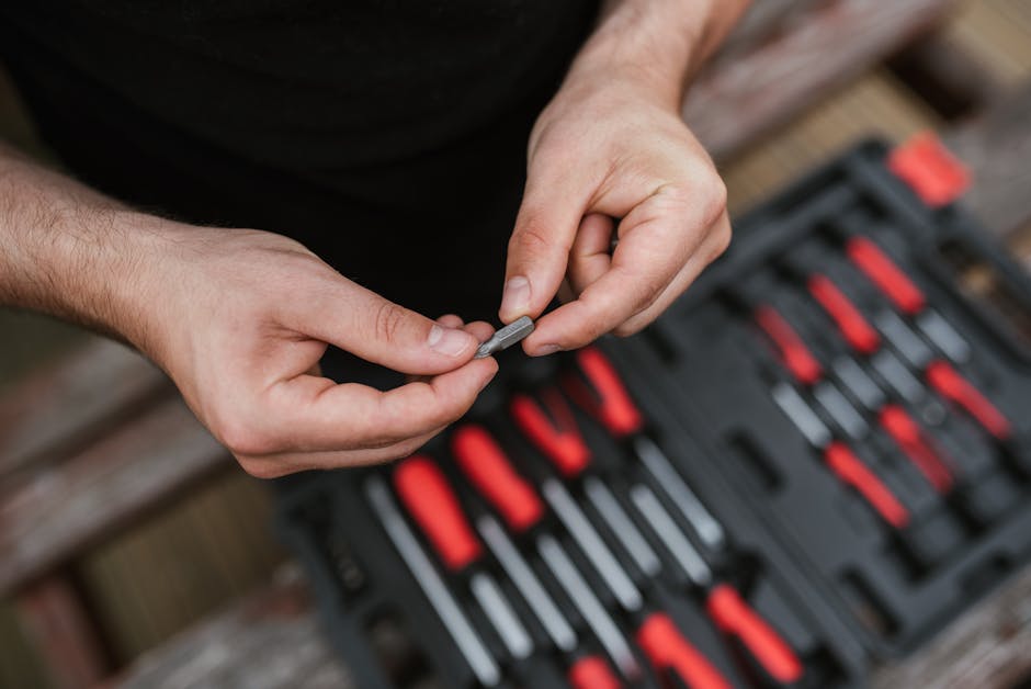 Close-up of hands with tools in a workshop, focusing on precision and skill.