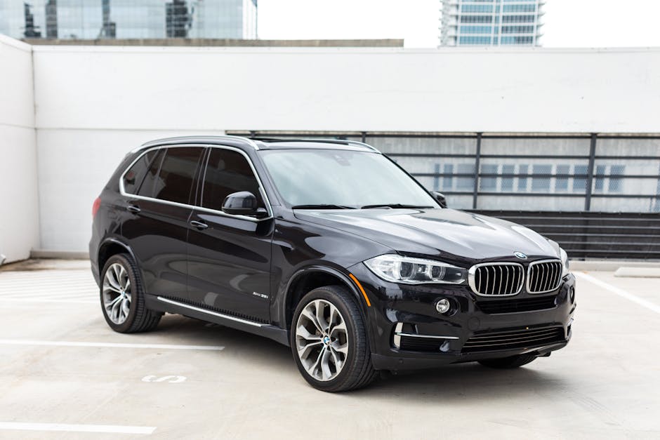 Sleek black BMW SUV parked in a modern urban area, highlighting luxury and style.