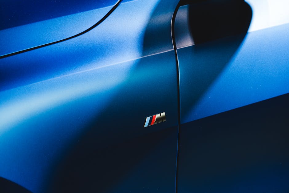 Close-up of a sleek blue car door with a prominent shadow and logo.